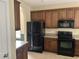 Modern kitchen featuring dark wood cabinets, black appliances, and ample counter space at 3609 White Oleander Ct., North Myrtle Beach, SC 29582
