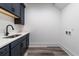 Laundry room with dark cabinets, quartz countertop, and vinyl flooring at 1302 Surf Pointe Dr., North Myrtle Beach, SC 29582