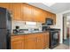 Condo kitchen with black appliances and wood cabinets at 1200 N Ocean Blvd. # 1002, Myrtle Beach, SC 29577