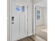 Inviting entryway with white door, wood floors, and view into adjacent room at 3050 Deerberry Place, Longs, SC 29568