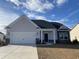 New construction home with gray siding and stone accents at 938 Oak Hollow St., Longs, SC 29568