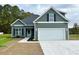 Newly constructed home with green siding, white trim, and a two-car garage at 110 Brian Oaks Trail, Aynor, SC 29511