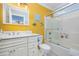 Bright bathroom with white vanity, shower/tub combo, and cheerful yellow walls at 919A N Waccamaw Dr., Murrells Inlet, SC 29576