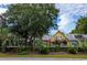 Yellow and orange colored homes with lush green landscaping and white fence at 120 A Da Gullah Way # A, Pawleys Island, SC 29585