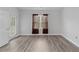 Bright bedroom with a window, door, and hardwood floors at 885 Palmetto Trail # 201, Myrtle Beach, SC 29577