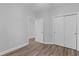 Bright bedroom with wood-look floors and double doors leading to a spacious closet at 885 Palmetto Trail # 201, Myrtle Beach, SC 29577