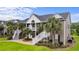 Two-story townhouse with gray siding, white trim, and stairs leading to the entrance at 885 Palmetto Trail # 201, Myrtle Beach, SC 29577