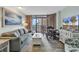 Bright living room with ocean view, comfortable seating, and large TV at 1501 S Ocean Blvd. # 1150, Myrtle Beach, SC 29577