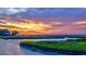 Stunning sunset over marsh with colorful clouds and a house in the distance at 10 Saltwater Way, Murrells Inlet, SC 29576