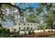 Two-story house with light blue shutters, landscaping, and large trees at 201 River Rd., Georgetown, SC 29440