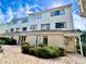 Three-story building with light-colored siding, landscaping, and a paved walkway at 209 75Th Ave. N # 10, Myrtle Beach, SC 29572