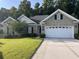 Front view of the house with a well-manicured lawn and a two-car garage at 709 Ashley Manor Dr., Longs, SC 29568