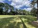 Scenic view of a lush green golf course with tall trees under a partly cloudy sky at 88 John Waites Ct., Georgetown, SC 29440