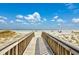 Wooden boardwalk leads to a sandy beach with ocean views at 7602 Porcher Dr. # C, Myrtle Beach, SC 29572