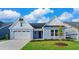 Two-story light blue house with white accents, two-car garage, and landscaped lawn at 1958 Woodrush Loop, Little River, SC 29566