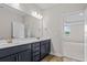 Double vanity bathroom with dark blue cabinets and gold fixtures, and bedroom view at 1958 Woodrush Loop, Little River, SC 29566