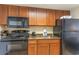 Small kitchen with dark wood cabinets and black appliances at 1105 S Ocean Blvd. # 1040, Myrtle Beach, SC 29577