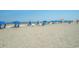 Beach with rows of blue umbrellas and lounge chairs at 1105 S Ocean Blvd. # 1040, Myrtle Beach, SC 29577
