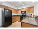 Well-equipped kitchen with black appliances and light wood cabinets at 1321 S Ocean Blvd. # 606, North Myrtle Beach, SC 29582