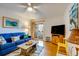 Living room featuring blue sofa, TV, and access to balcony at 1582 S Waccamaw Dr. # 10, Murrells Inlet, SC 29576