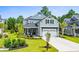 Two-story home with light green siding, a metal roof, and a landscaped lawn at 2056 Summer Rose Ln., Myrtle Beach, SC 29579