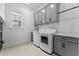 Bright laundry room with gray cabinets, white appliances, and herringbone tile floor at 2056 Summer Rose Ln., Myrtle Beach, SC 29579