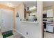 Galley kitchen with white cabinets and view into adjacent living area at 8862 Cloister Dr. # F, Myrtle Beach, SC 29575