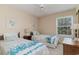Spacious bedroom with twin beds, window, and ceiling fan at 8862 Cloister Dr. # F, Myrtle Beach, SC 29575