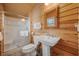 Clean bathroom with pedestal sink, shower, and wood-paneled walls at 496 Myrtle Ave., Pawleys Island, SC 29585