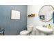 Powder room with blue textured walls, pedestal sink, and oval mirror at 193 Hadley Springs Ave, Longs, SC 29568
