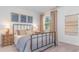 Spacious bedroom with a metal bed frame, neutral bedding, and tasteful wall art at 201 Hadley Springs Ave, Longs, SC 29568