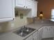 Bright kitchen features white cabinets, stainless steel sink, and ample counter space at 5011 Harvest Dr. # 203, Myrtle Beach, SC 29579