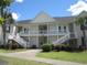 Two-story condo building with white siding and stairs at 5011 Harvest Dr. # 203, Myrtle Beach, SC 29579