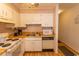 Simple kitchen with white cabinets, stove, and dishwasher at 4305 S Ocean Blvd. # 106, North Myrtle Beach, SC 29582