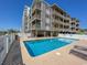 Community pool with lounge chairs and surrounding patio at 4305 S Ocean Blvd. # 106, North Myrtle Beach, SC 29582