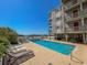 Community pool with lounge chairs and ocean view at 4305 S Ocean Blvd. # 106, North Myrtle Beach, SC 29582
