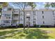 Three-story building with grey siding, balconies, and ample green space at 351 Lake Arrowhead Rd. # 11-342, Myrtle Beach, SC 29572