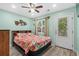 Bedroom with floral bedding, ceiling fan, and exterior access at 6001-1573 S Kings Hwy., Myrtle Beach, SC 29575