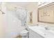 Clean bathroom with shower/tub combo, white vanity, and decorative mirror at 6001 S Kings Hwy., Myrtle Beach, SC 29575