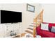 Cozy living room featuring a red couch and wooden staircase at 6001 S Kings Hwy., Myrtle Beach, SC 29575