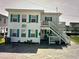 Two-story beach house with teal accents and a staircase at 329 54Th Ave. N, North Myrtle Beach, SC 29582