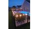Night view of a backyard pool with string lights and a fence at 1459 Tiger Grand Dr., Conway, SC 29526