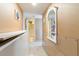 Bright hallway with mirror and artwork leading to a bathroom at 1605 S Ocean Blvd. # 1104, Myrtle Beach, SC 29577