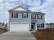 Two-story house with light blue vinyl siding, white garage door, and landscaping at 322 Acosta Circle, Conway, SC 29527