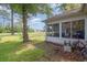 View of backyard with screened porch, landscaping, and a bicycle at 6458 Sweet Gum Trail, Myrtle Beach, SC 29588