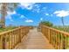 Wooden boardwalk leads to sandy beach with colorful umbrellas at 201 74Th Ave. N # 1002, Myrtle Beach, SC 29572