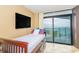 Guest bedroom with a twin bed, large TV, and sliding glass door leading to ocean view at 201 74Th Ave. N # 1002, Myrtle Beach, SC 29572