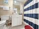 Bathroom with toilet, vanity, and striped shower curtain at 758 Parker Dr., Pawleys Island, SC 29585