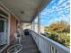Porch with rocking chairs, small table and partial ocean view at 758 Parker Dr., Pawleys Island, SC 29585