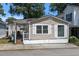 Tan colored house with white trim, front porch, and small yard at 6001 - 1824 S Kings Hwy., Myrtle Beach, SC 29575